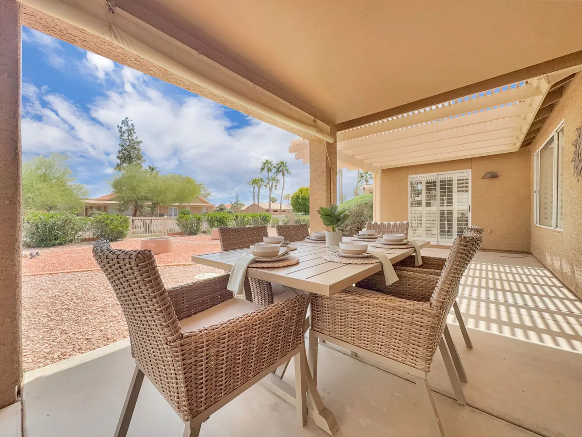 The image highlights an outdoor dining table with wicker chairs overlooking a serene landscape view. The setting suggests an ideal spot for relaxing or socializing after a day on the golf course, echoing the section’s mention of unwinding at clubhouses.