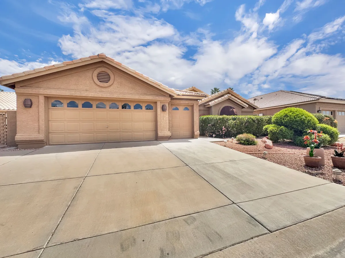 A bright exterior view of the home's garage door, driveway, and well-maintained front yard landscaping. The inviting entrance hints at both curb appeal and the potential for vibrant outdoor gatherings.